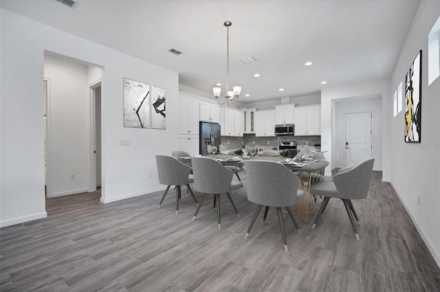 dining room with hardwood / wood-style flooring and a notable chandelier