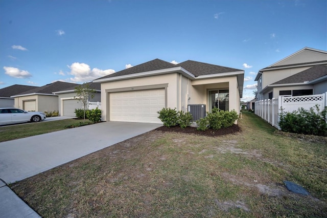 view of front of house featuring a garage, cooling unit, and a front yard