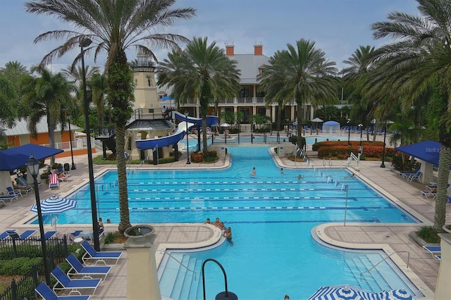 view of swimming pool featuring a water slide and a patio area