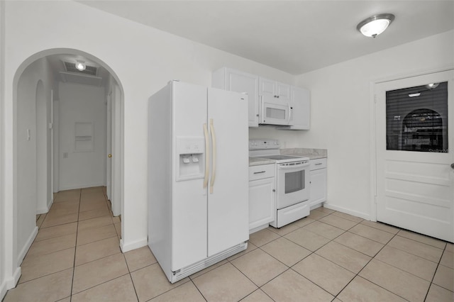 kitchen featuring light tile patterned flooring, white cabinets, and white appliances