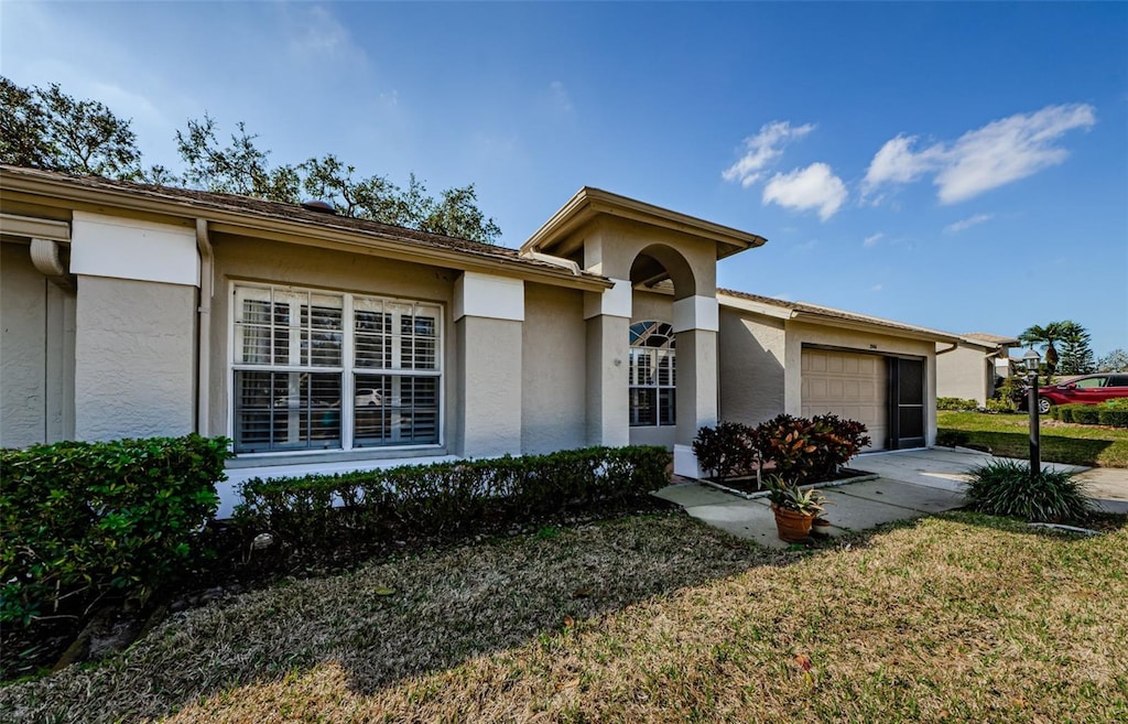 ranch-style home with a garage and a front lawn