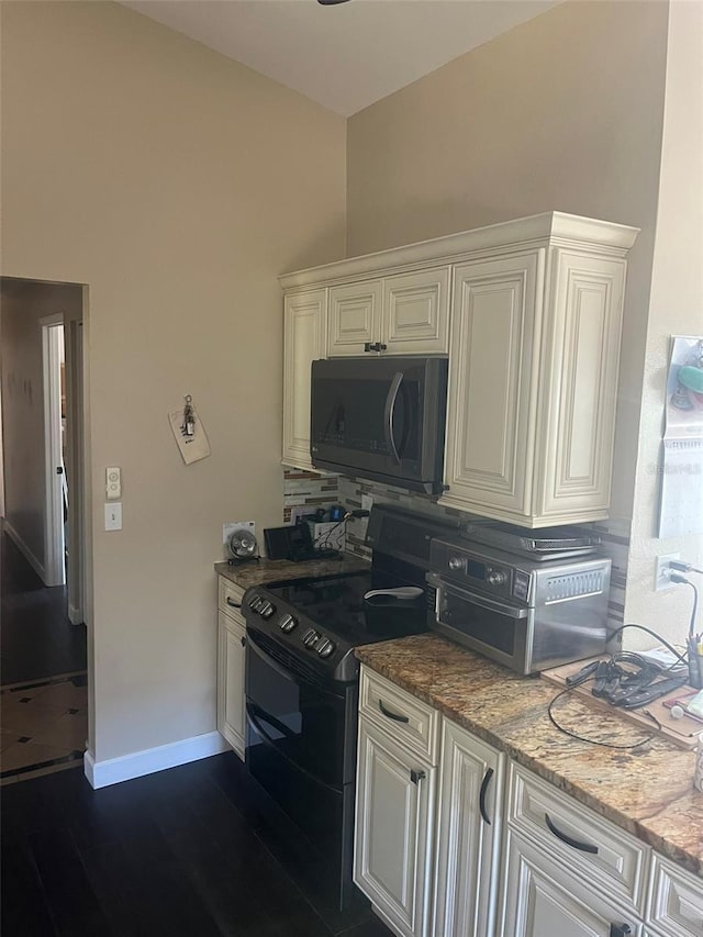 kitchen featuring dark hardwood / wood-style flooring, white cabinetry, light stone countertops, and range with two ovens