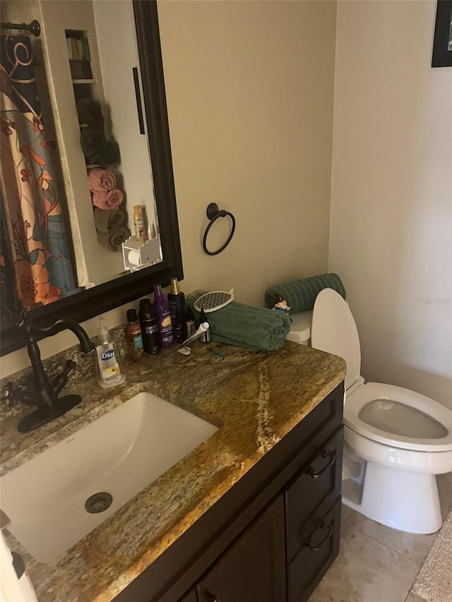 bathroom featuring vanity, tile patterned floors, and toilet