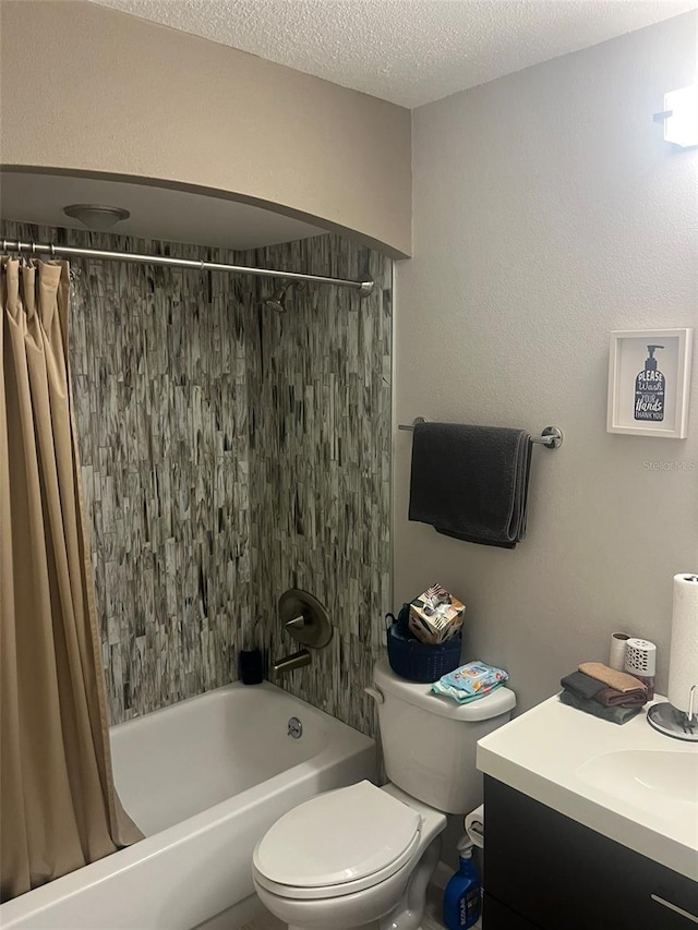 full bathroom featuring shower / tub combo with curtain, vanity, toilet, and a textured ceiling