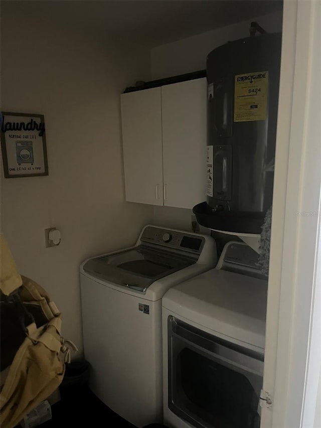 laundry area featuring independent washer and dryer, cabinets, and electric water heater