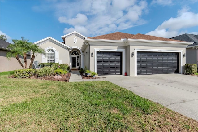 ranch-style home featuring a garage and a front lawn