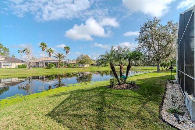 view of yard with a water view and a lanai