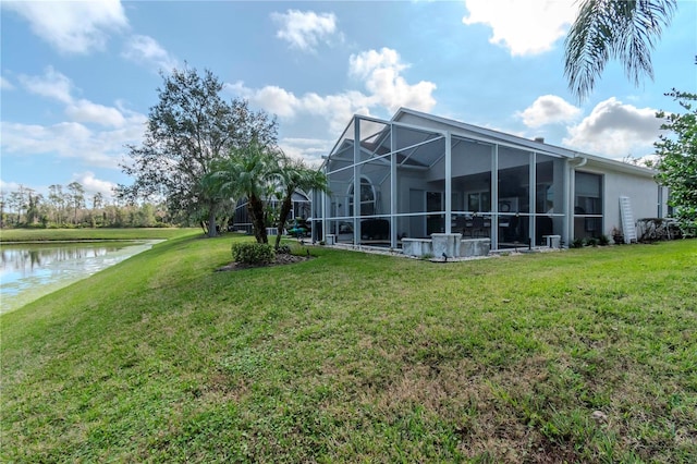 rear view of property featuring a water view, a yard, and glass enclosure