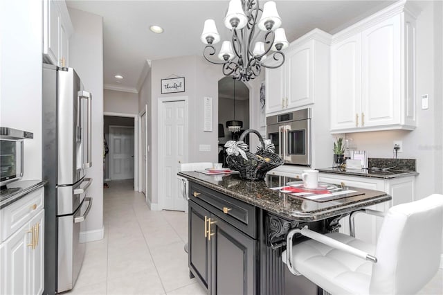 kitchen with high end fridge, a kitchen island, pendant lighting, dark stone counters, and white cabinets