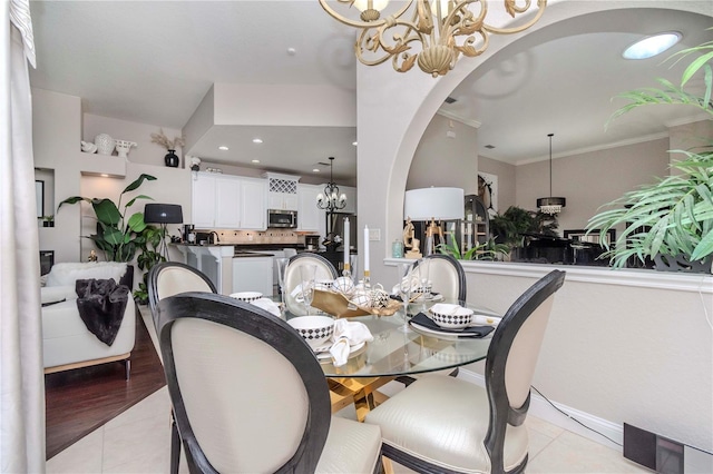 dining area with a notable chandelier, ornamental molding, and light tile patterned flooring