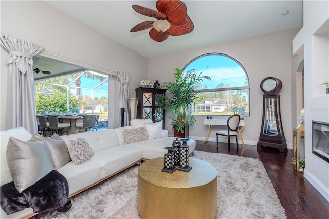 living room featuring ceiling fan, plenty of natural light, and dark hardwood / wood-style floors