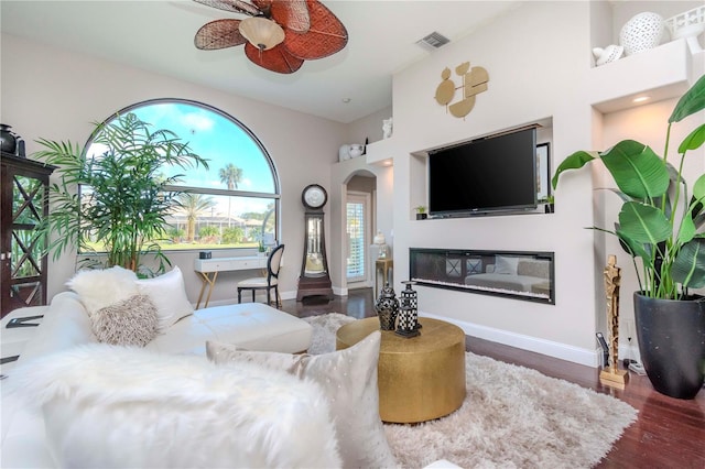 living room featuring ceiling fan and dark hardwood / wood-style floors