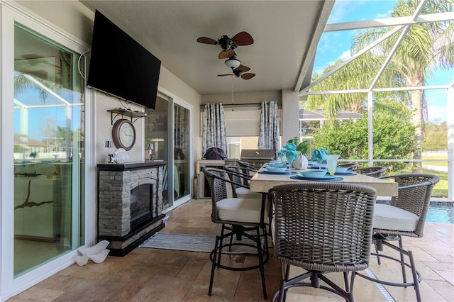 view of patio with ceiling fan and glass enclosure