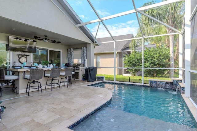 view of swimming pool featuring exterior bar, area for grilling, pool water feature, a lanai, and a patio area