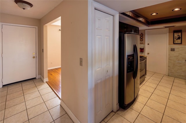 kitchen with a tray ceiling, light tile patterned flooring, and appliances with stainless steel finishes