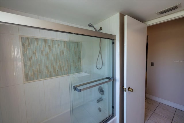 bathroom with combined bath / shower with glass door and tile patterned floors