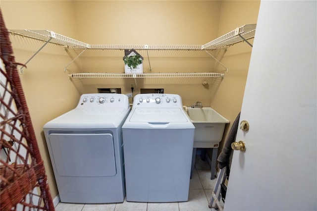 washroom with sink, light tile patterned floors, and washer and dryer