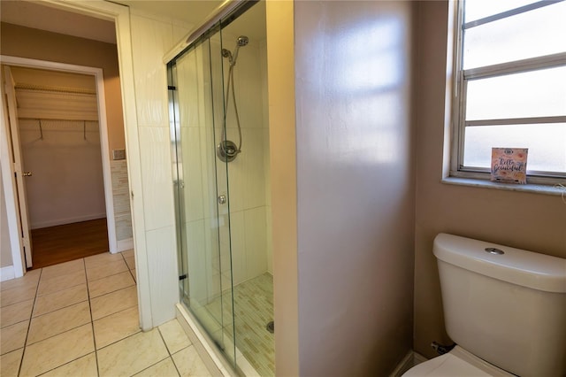 bathroom with tile patterned flooring, toilet, and walk in shower