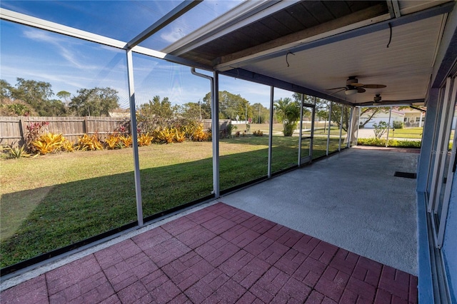 unfurnished sunroom with ceiling fan