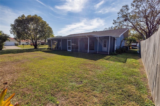 back of house with a lawn and a sunroom