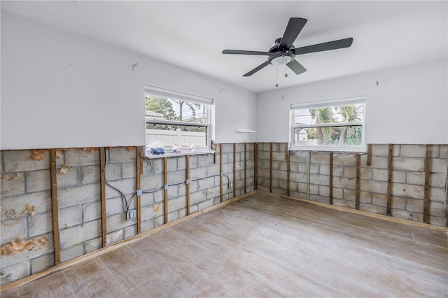 spare room with plenty of natural light, ceiling fan, and light hardwood / wood-style flooring