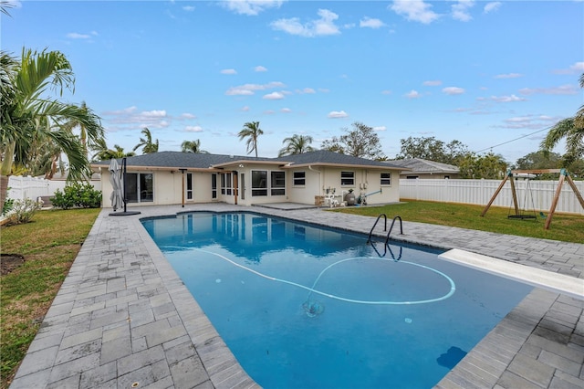 view of pool featuring a playground, a patio area, and a lawn