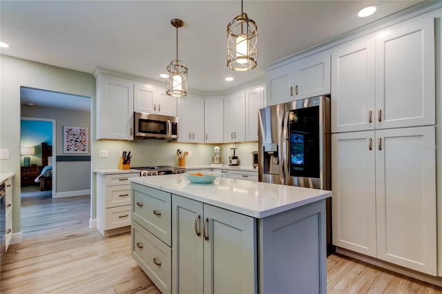 kitchen with light hardwood / wood-style flooring, a kitchen island, pendant lighting, stainless steel appliances, and white cabinets