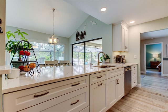 kitchen with dishwasher, sink, white cabinets, and light stone counters