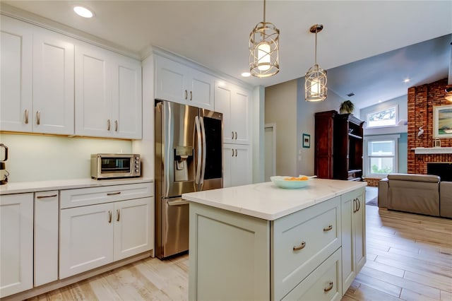 kitchen featuring pendant lighting, a center island, stainless steel fridge with ice dispenser, and white cabinets