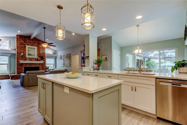 kitchen featuring sink, lofted ceiling with beams, hanging light fixtures, stainless steel dishwasher, and a fireplace