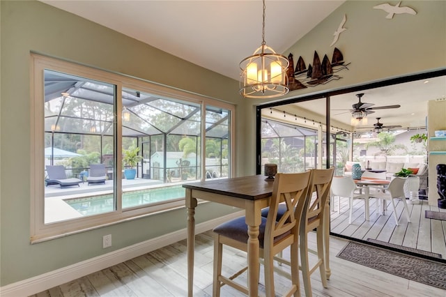 dining room featuring vaulted ceiling, a notable chandelier, and light wood-type flooring