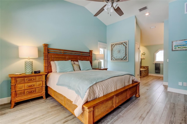 bedroom featuring connected bathroom, hardwood / wood-style flooring, high vaulted ceiling, and ceiling fan