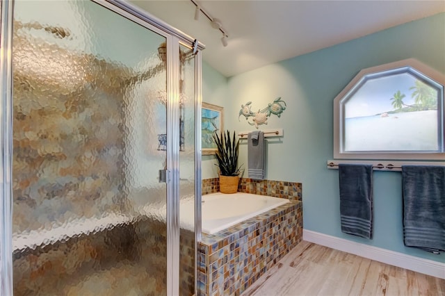 bathroom featuring independent shower and bath, rail lighting, and wood-type flooring