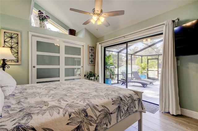 bedroom featuring multiple windows, lofted ceiling, and access to exterior