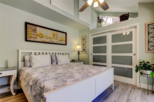 bedroom with ceiling fan, lofted ceiling, and light hardwood / wood-style floors