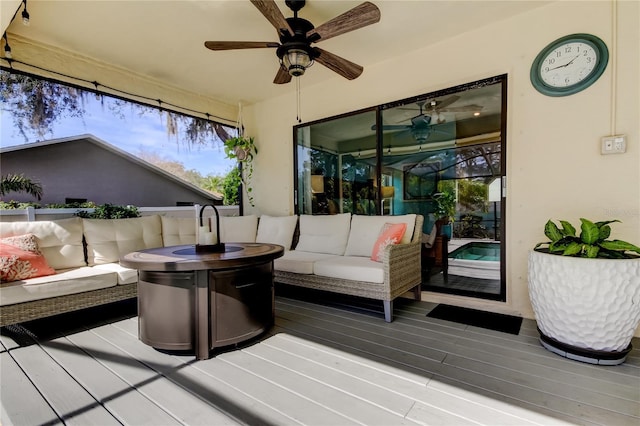 deck with ceiling fan and an outdoor living space