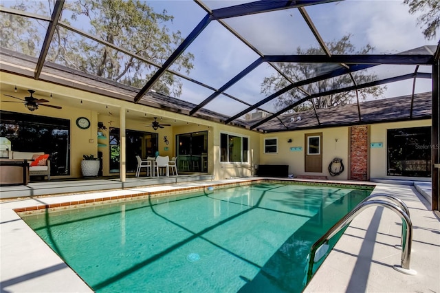 view of swimming pool with ceiling fan, a lanai, and a patio