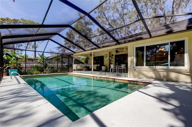 view of swimming pool with a lanai, outdoor lounge area, ceiling fan, and a patio area