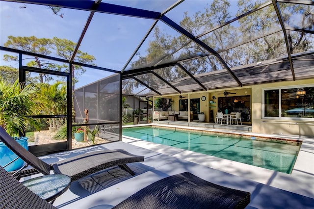 view of swimming pool with ceiling fan, an outdoor hangout area, a patio area, and a lanai