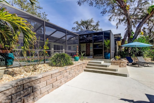 back of house featuring a patio area and glass enclosure