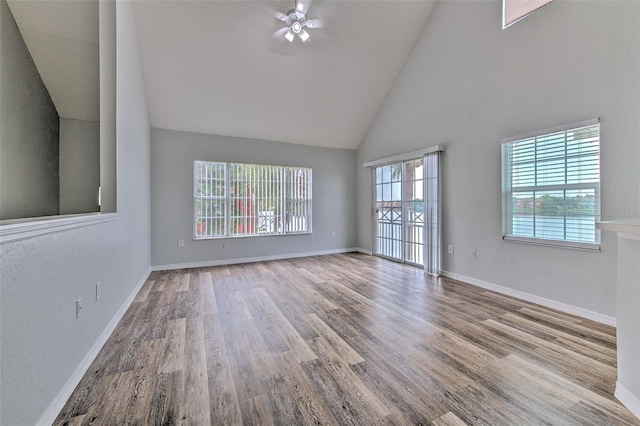 spare room with ceiling fan, high vaulted ceiling, and light wood-type flooring