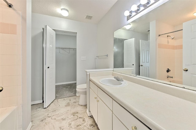 full bathroom with shower / tub combination, vanity, a textured ceiling, and toilet