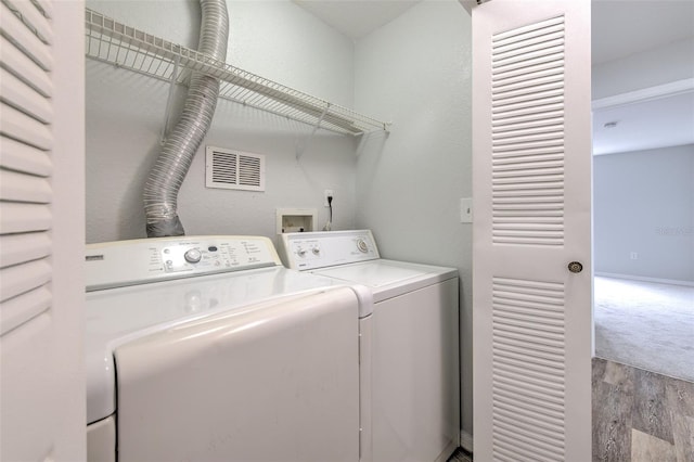 laundry area featuring washing machine and clothes dryer and light wood-type flooring