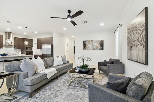 living area with crown molding, recessed lighting, visible vents, and ceiling fan