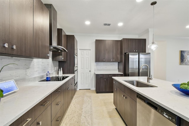 kitchen featuring dark brown cabinetry, visible vents, wall chimney exhaust hood, appliances with stainless steel finishes, and a sink