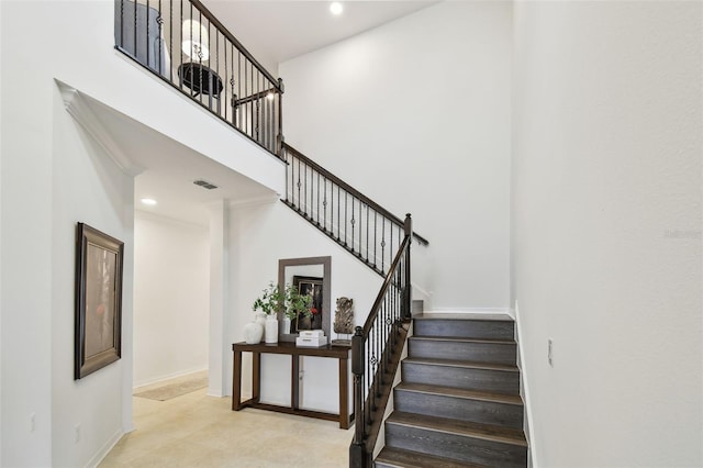 stairs featuring recessed lighting, baseboards, and a high ceiling