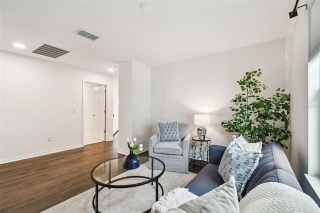 living room with recessed lighting, visible vents, baseboards, and wood finished floors