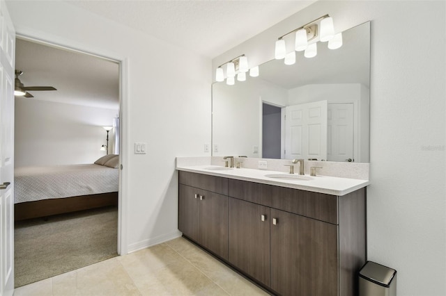 bathroom featuring double vanity, a ceiling fan, a sink, ensuite bath, and tile patterned flooring