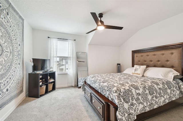 bedroom with light colored carpet, a ceiling fan, vaulted ceiling, a textured ceiling, and baseboards