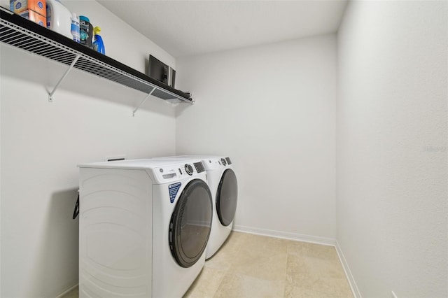 laundry area featuring laundry area, baseboards, and separate washer and dryer